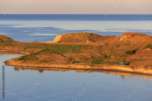 Camping on remote island with a campervan during sunrise near ocean