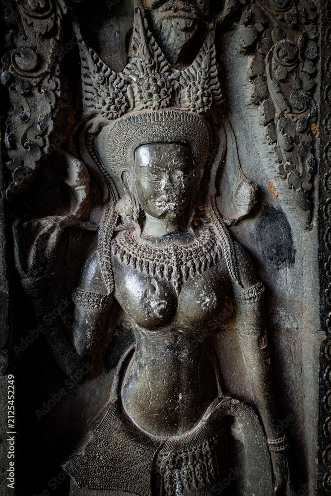 Fototapeta premium Ancient stone carving of a female Apsara dancer inside Angkor Wat temple in Siem Reap, Cambodia