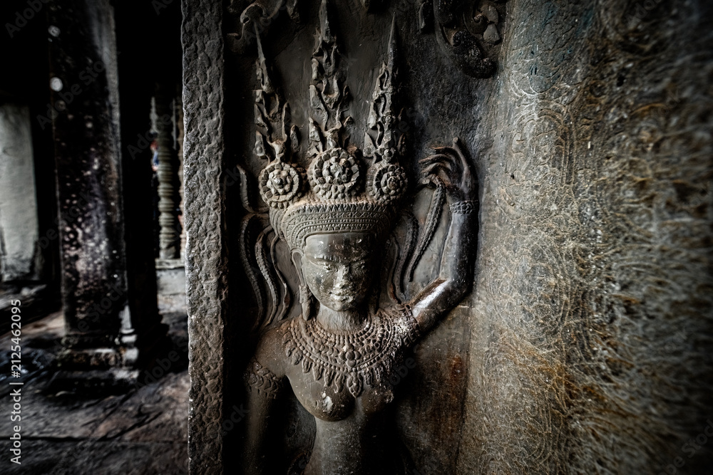 Fototapeta premium Ancient stone carving of a female Apsara dancer inside Angkor Wat temple in Siem Reap, Cambodia