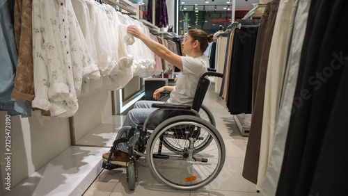 Obraz na plátne A Caucasian woman in a wheelchair shopping at a mall.