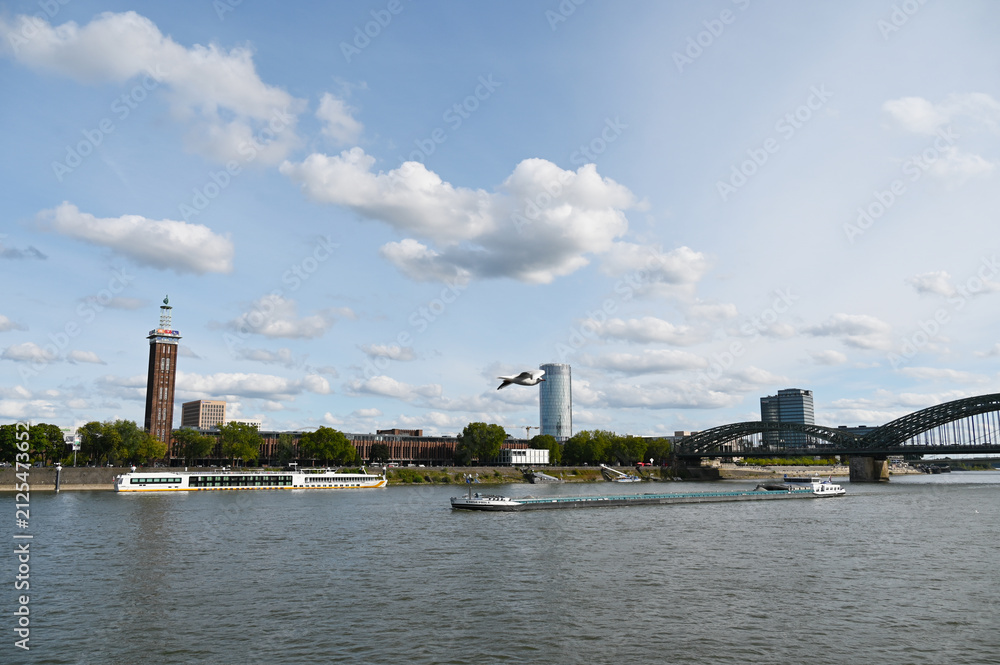 Fototapeta premium Köln, Rhein, ehemaliger Messeturm, RTL-Studios, Triangel-Hochhaus, Hohenzollernbrücke, Binnenschiff, Kreuzfahrtschiff