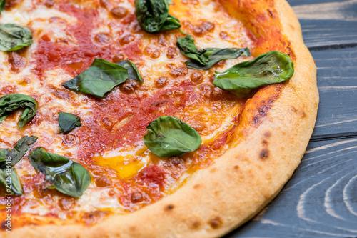 gluten-free pizza topped with tomato sauce, cheese, and fresh basil leaves.