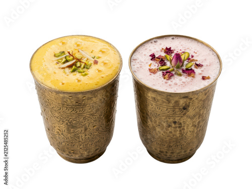 Two traditional indian lassi yogurt drinks in decorated metal cups with crushed nuts and dried rose petals on top isolated on transparent background