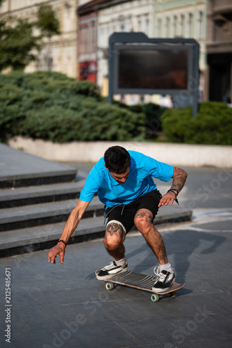 Cuadro en lienzo Tattooed man skateboarding in urban park