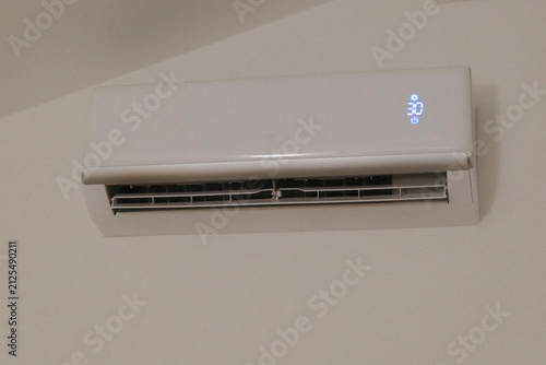 Cuadro en lienzo White air conditioner unit mounted on a indoor wall displays thirty degrees Cels