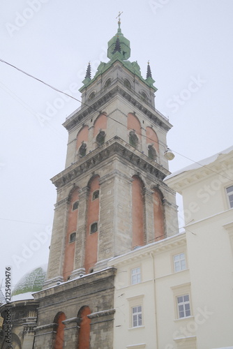 Photography Ancient stone bell tower stands in the city center of Lviv under a cloudy winter