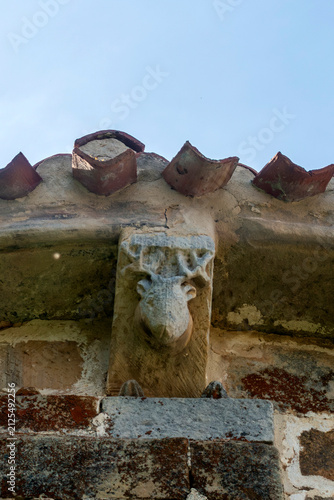 фотографія Sculpted Romanesque corbel representing a deer head under the eaves of the Churc