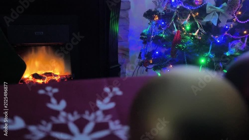 New Year's table with a fireplace and a New Year's tree in the background in the dark 