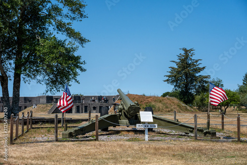 фотографія Large artillery gun and US flags at Historic military installation at Fort Steve