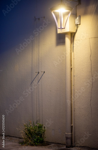 Urban night scene with street light and textured wall