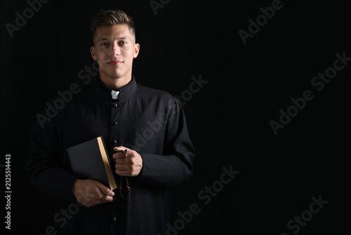 Konstfotografi Portrait of priest with Holy Bible and rosary on black background