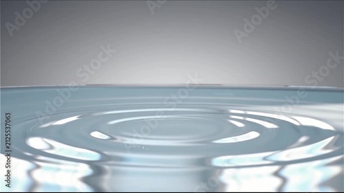 Crystal Clear Water Droplet Creating Smooth Ripples in Calm Water