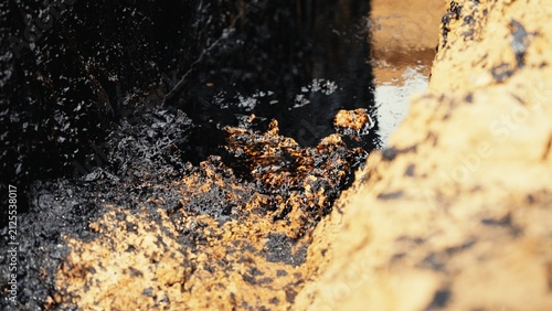 Fotografía Black crude oil polluting the ground and water, creating an environmental disast