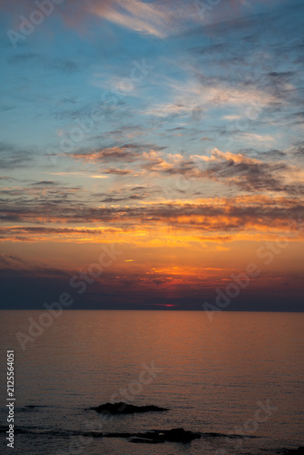 夕暮のオレンジ色の夕焼雲とオレンジ色に反射する海面
