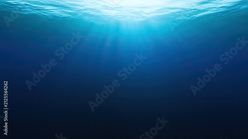 Sunbeams pierce the deep blue ocean, illuminating the dark water below