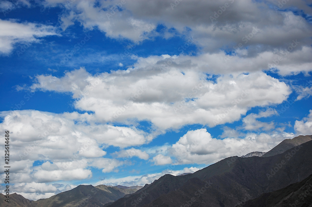 Obraz premium Blue sky with white clouds and mountain range under it