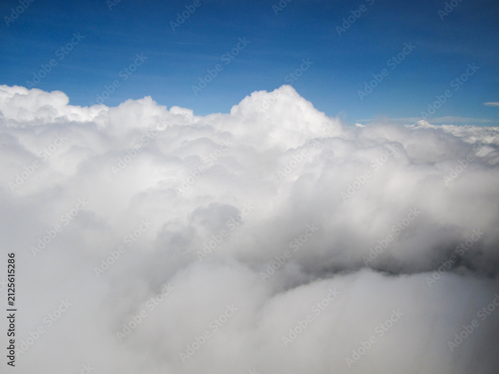 Obraz premium Vast expanse of fluffy white clouds under a clear blue sky