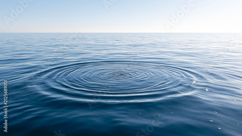 Concentric Ripples Expanding Across a Calm Blue Ocean Surface Beneath a Pale Open Sky