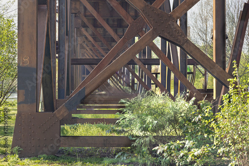 Photography Geometric oxidized iron beams and rivets supporting a train trestle in historic Shockoe Bottom, Richmond, Virginia