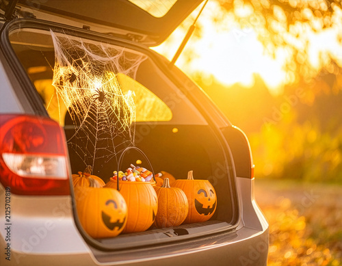 Car decorated for Trunk or Treat, an alternative for kids Trick or Treating in a safe environment on Halloween night. Golden autumn foliage trees in the background with copy space.