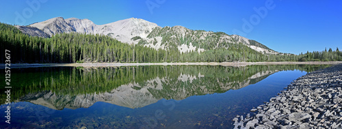 Panorama of Mt Sopris reflected in calm water of second Thomas Lake in White River National Forest near Carbondale, Colorado on sunny summer morning.