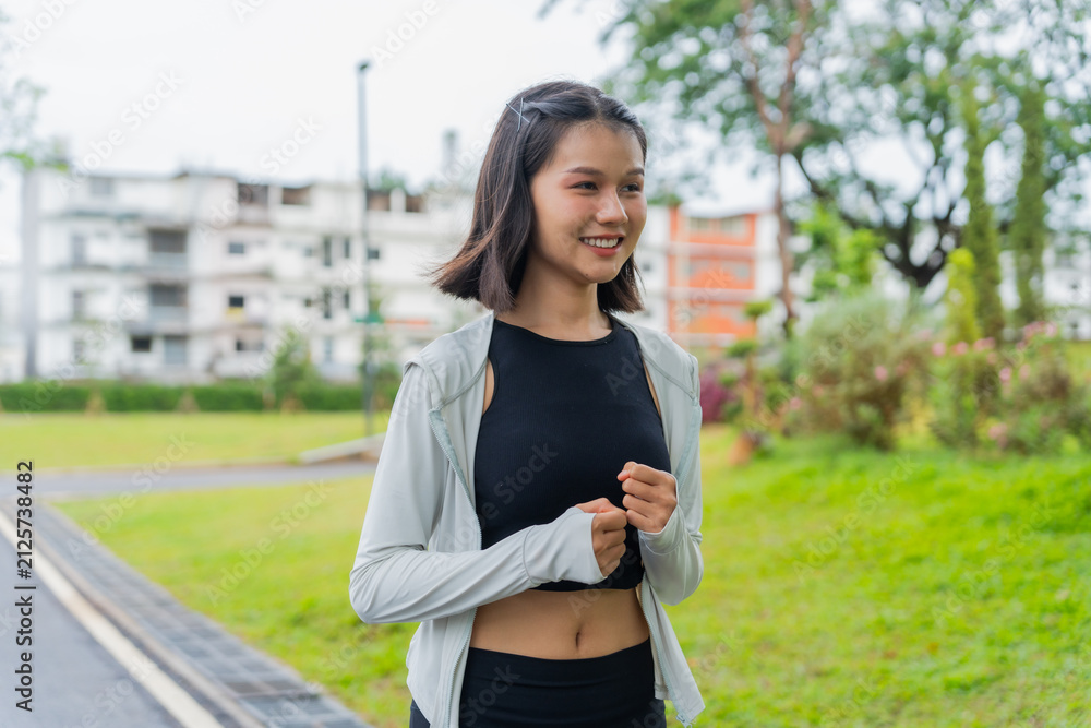 Fototapeta premium Asian sporty woman running in public park