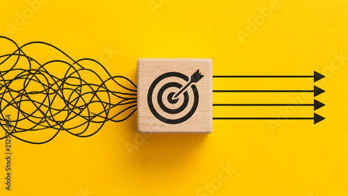 Tangled lines passing through a target wooden cube and emerging as straight arrows on yellow background. Simplified business strategy concept vector illustration. Ideal for focus banners.