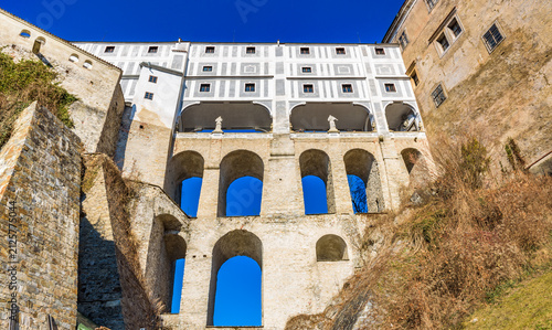 Multi-arched Cloak Bridge of Cesky Krumlov Castle viewed from below under clear blue sky, Czechia, UNESCO World Heritage Site