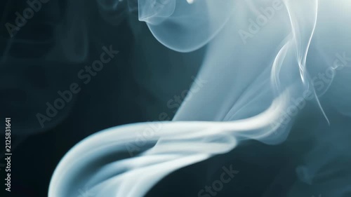 A mesmerizing swirl of white smoke against a dark background, creating abstract shapes. 4k Video footage.