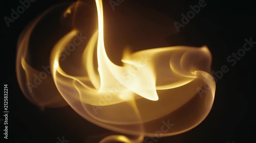 A dynamic swirl of bright golden fire moving in a dark space, creating a mesmerizing effect. 4k Video footage.