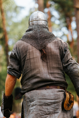 Canvas Print A person dressed in medieval clothing walks through a forest during a festival