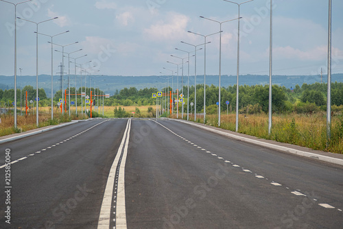 Obraz na płótnie Empty asphalt highway road with street light poles. Modern road infrastructure