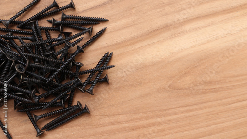 Top View Pile of Drywall Screws on Wooden Surface with Copy Space