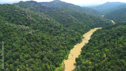Drone flyover with gentle horizontal reveal of the winding Sungai Tembeling through pristine primary rainforest and rolling hills near Taman Negara, Pahang, Malaysia.