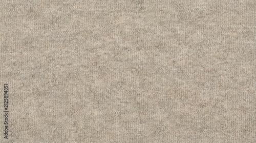 Close up of beige knitted fabric texture with a subtle heathered pattern for backgrounds and textile designs