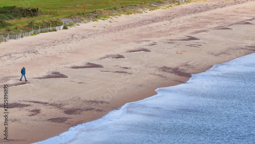 Obraz na plátně Solitary Person Walking Along Rosemarkie Sandy Beach Shoreline in Scotland