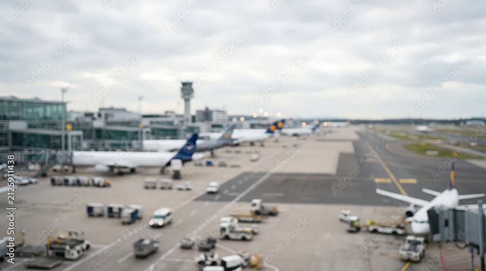 Fototapeta premium blurred airport tarmac airplanes terminal building control tower aviation travel transportation background bokeh out of focus runway flight
