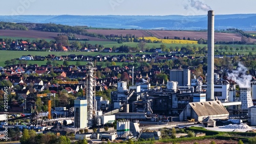 Konstfotografi Industrial Plant and Smokestack Beside Rural Town and Farmland