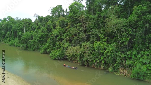 Drone following a traditional longboat along Sungai Tembeling through primary tropical rainforest, Al-Sultan Abdullah Royal Tiger Reserve, Pahang, Malaysia