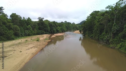 Drone rising above longboat on Sungai Tembeling revealing primary tropical rainforest, Al-Sultan Abdullah Royal Tiger Reserve, Pahang, Malaysia