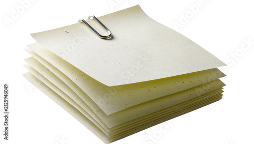 Fotografie Stack of pale yellow paper notes held together by a silver paperclip, isolated o