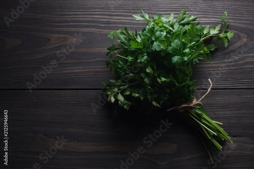 Fresh bunch parsley on dark wooden table