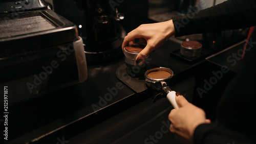 фотографія Barista Tamping Fresh Ground Coffee in Portafilter for Espresso Preparation