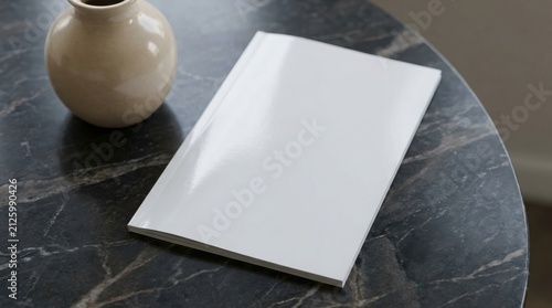 A blank magazine cover mockup rests on a dark marble table next to a decorative ceramic vase.