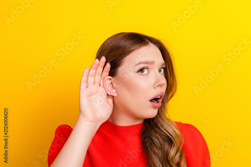 фотографія Young woman holding hand to ear listening with surprised expression against brig