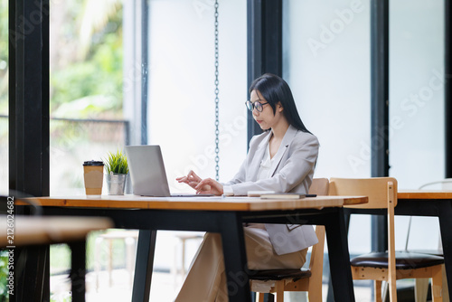 Принти на полотні Businesswoman working on laptop in modern office, professional concentrating on