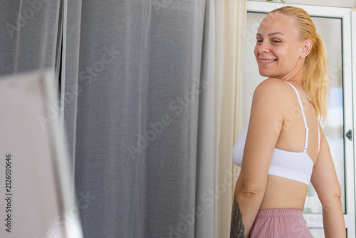 Quadro su tela Young woman smiling, turning head while looking back, feeling happy and positive