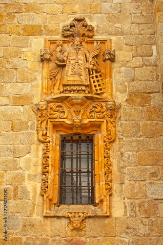 Ornate Stone Carving and Barred Window on Historic European Facade