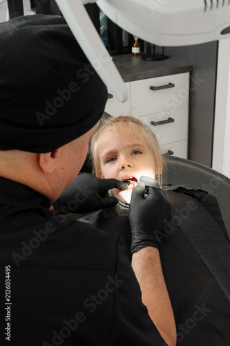 Foto Dentistry, little girl receiving professional dental treatment during an oral ex