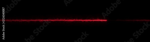 Bild auf Leinwand Red laser beam line interrupted by a dark silhouette